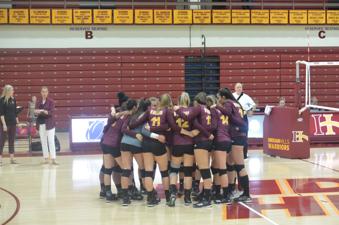 Volleyball Team huddling together on the court.